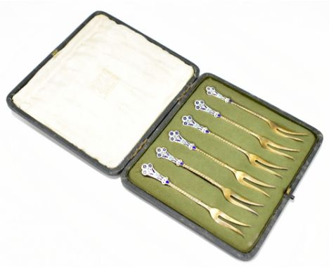 A set of six Norwegian silver gilt and enamel pickle forks, with enamel detail, the enamel handles with floral detail, fitted