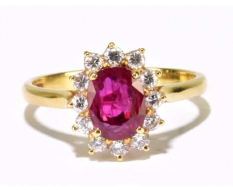 An 18ct yellow gold ruby and diamond oval cluster ring, centred with an oval ruby within a border of twelve round, one claw s