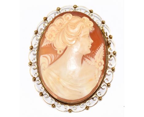 A large yellow metal framed shell cameo brooch carved with a profile portrait of a young woman, 7cm, approx 22.6g.Additional 