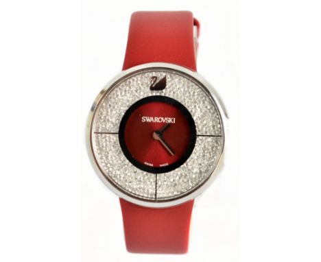 SWAROVSKI; a lady's dress watch with silver tone stainless steel case and embellished with crystals to the red watch face and