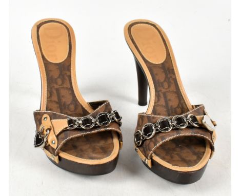 CHRISTIAN DIOR; a pair of brown and tan monogram logo cloth heeled mules with wooden wooden stiletto and platform, trimmed wi