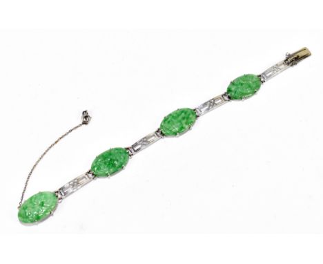 A cased 9ct yellow gold and carved jade bracelet with four oval panels of jade within a pierced framework to box clasp and sa