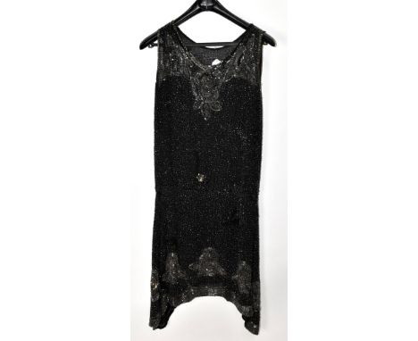 A 1920s black silk sleeveless flapper dress heavily decorated with decorative sequins and bugle beads, with an irregular from