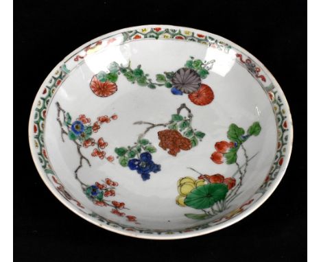 A 19th century Chinese Famille Verte porcelain dish decorated with floral sprays inside checkered border with four auspicious