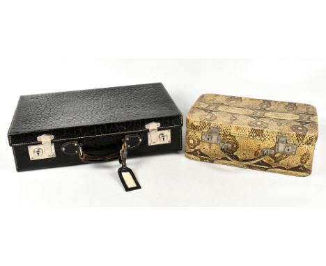 A vintage black embossed leather travel vanity case, fitted with an incomplete set of white metal topped perfume bottles, wit