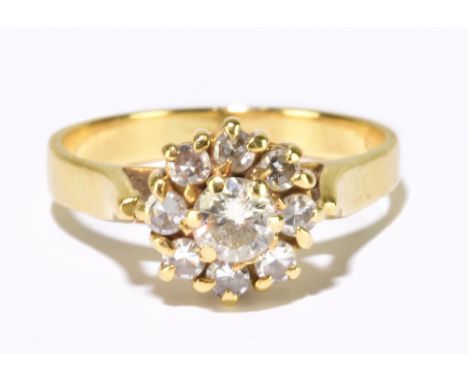 An 18ct yellow gold and diamond flower head ring, set with nine round brilliant cut diamonds, the centre stone weighing appro