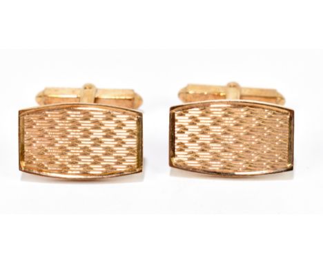 A pair of 9ct yellow gold cufflinks with engraved detail to the tonneau shaped platforms, approximately 10.95g.&nbsp;Addition