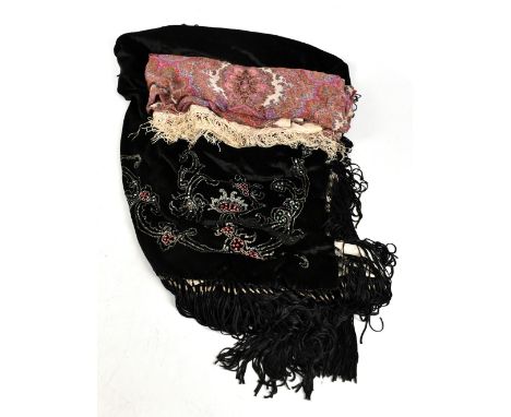 An early 20th century silk paisley shawl with boteh and other motifs in red, greens, blues and gold, with cream edges and sil