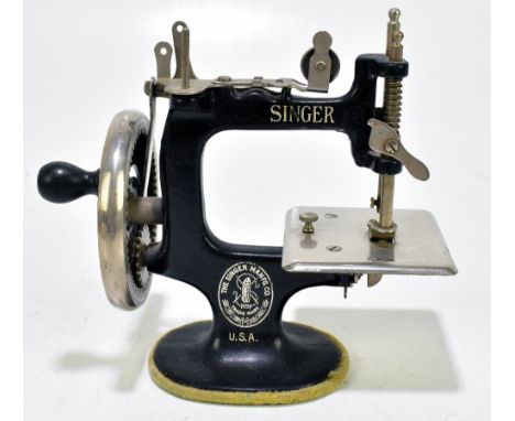 SINGER; a child's MO20 sewing machine, complete with instruction manual.Additional InformationThe miniature machine is presen