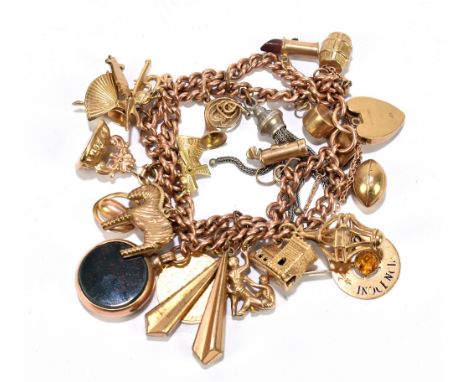 A 9ct gold charm bracelet, with numerous charms including half sovereign with shield back dated 1887,&nbsp; a church, a whist