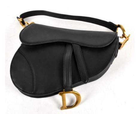 A black leather saddle shaped handbag with front flap with magnetic D-stirrup with gold tone hardware and back pocket, 25 x 2