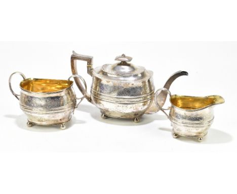 GEORGE FENWICK; a George III hallmarked silver three piece tea service with chased floral decoration to the upper body below 