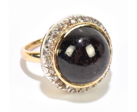 A yellow metal dress ring set with a central large garnet flanked by a melee of diamonds, size G, approximate weight 8.2g.&nb