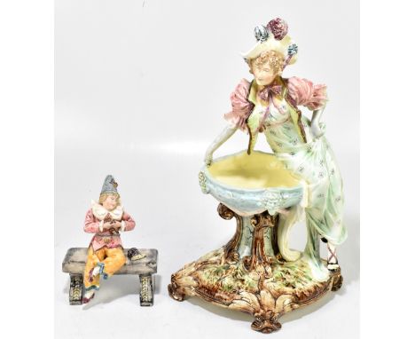 An Art Nouveau style figure of a lady sitting on a large bowl, height 44cm, together with a smaller figure of a man sitting o