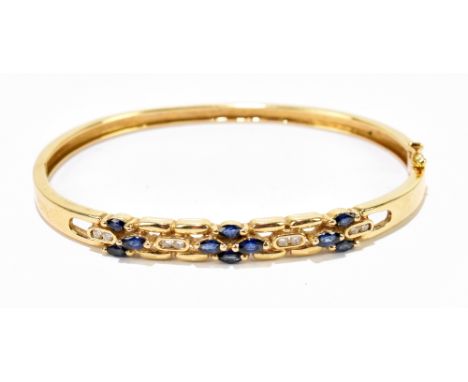 A 14ct yellow gold sapphire and diamond set oval hinged snap bangle with box clasp and figure of eight safety clasp set with 