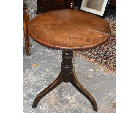 A George III provincial oak circular tripod table, with fixed top on turned column, height 67cm, diameter 52cm.