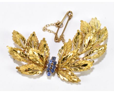 An 18ct yellow gold leaf brooch, set with eight small sapphires, and safety chain, width 5cm, approximately 10.45g.&nbsp;Addi