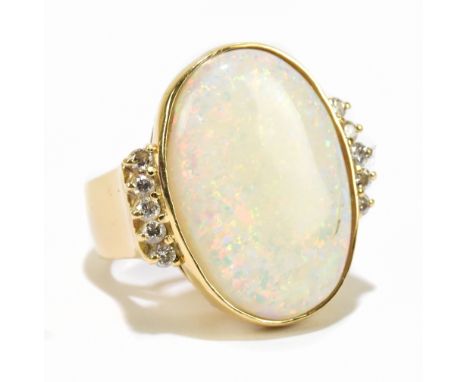 A large 18ct yellow gold opal and diamond dress ring, the central oval opal flanked by ten small round brilliant cut diamonds