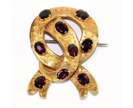 A yellow metal and garnet ribbon brooch set with nine oval faceted garnets, 34 x 23mm, approx 4.16g.Additional InformationAcc