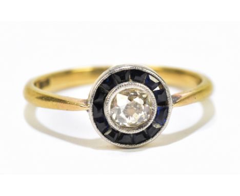 An Art Deco yellow metal target ring, set with a central old cut diamond flanked by sapphires,&nbsp;approximate size M 1/2,&n