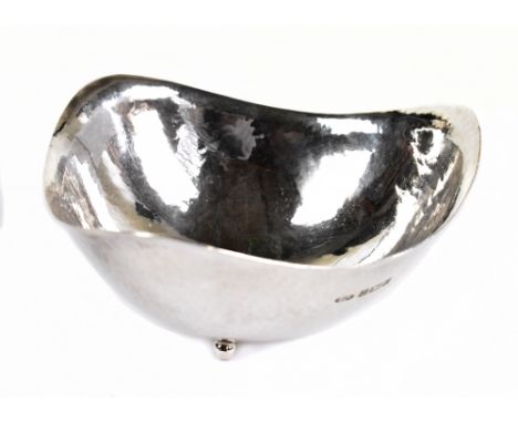 AE JONES; a hallmarked and planished silver bowl of triangular form, on three circular feet, Birmingham 1964, 4.5ozt/141g, wi