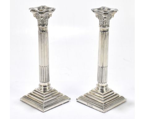 WI BROADWAY &amp; CO; a pair of Elizabeth II hallmarked silver Corinthian column candlesticks, Birmingham 1982, height 27cm (