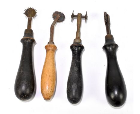 A group of four leather making tools.