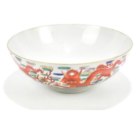 A Chinese porcelain Famille Verte footed bowl decorated with four claw dragons chasing the Pearl of Wisdom, bears painted sty