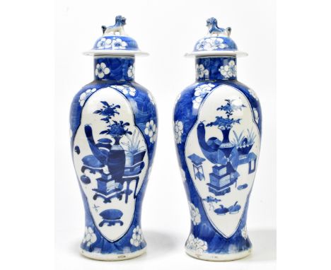 A pair of late 19th century Chinese blue and white porcelain lidded vases decorated with objects in lozenge shaped panels ins