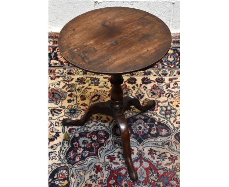 A George III oak circular tripod table, with fixed top and turned column on tripod base, height 67cm, diameter 51cm.&nbsp;