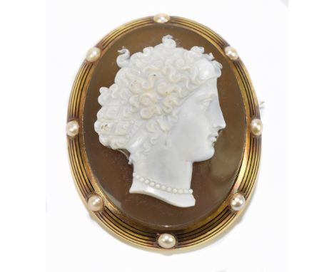 A Victorian yellow metal oval cameo brooch, decorated with the portrait of a maiden with curly hair and bead necklace, the mo