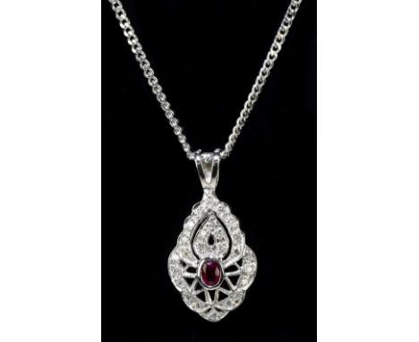 An 18ct white gold ruby and diamond pierced oval pendant suspended on an 18ct white gold curb link chain, length of chain 36c