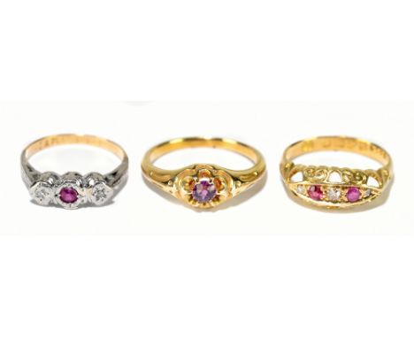 An 18ct yellow gold ruby and diamond five stone half hoop ring, size J, and two yellow metal rings sizes K and H, combined ap