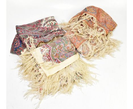Three large early 20th century 100% wool paisley scarves each with plain centres, pattern borders and wool fringing, all 135 