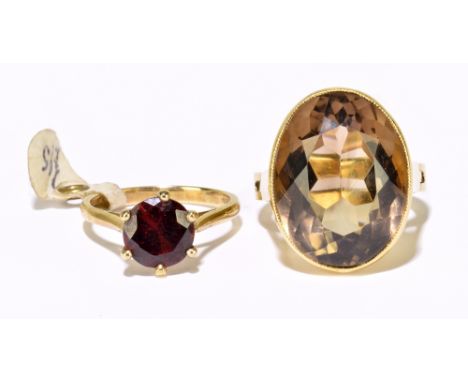 A 9ct yellow gold garnet claw set ring, size I, approx. 2.7g, and a yellow metal smoky quartz set ring, size J 1/2 (open P 1/