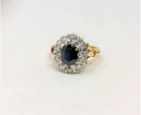 An 18ct gold diamond and sapphire cluster ring, the oval sapphire weighing approximately 1.60 carats, within a border of ten 