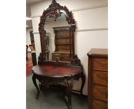 A heavily carved console table on cabriole legs with mirror back, width 137 cm