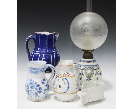 A mixed group of pottery and porcelain, 19th and 20th century, including three faience jugs, a heart shaped colander, an oil 