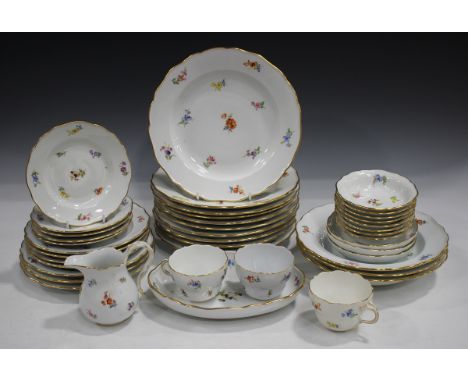 A Meissen porcelain part service, 20th century, painted with scattered flowers beneath shaped gilt edged rims, comprising ten