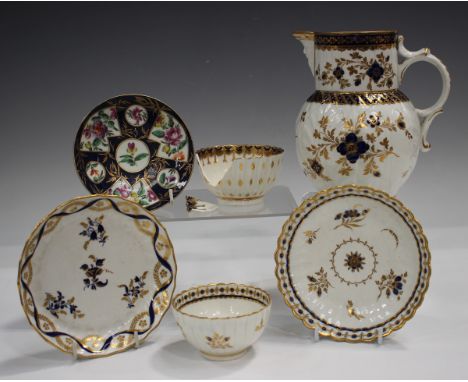 A Caughley fluted teabowl and saucer, circa 1775, decorated in blue and gilt with scattered floral sprigs around a central me