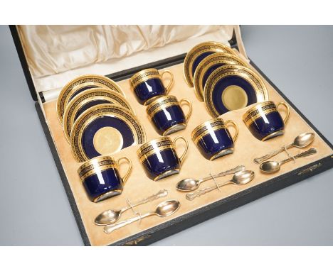 A cased set of six Limoges coffee cups and saucers, six silver gilt spoons