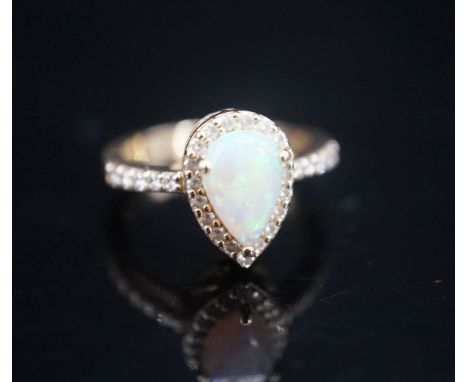 A modern 14k yellow meta, white opal and diamond set pear shape cluster ring, with diamond set shoulders, size K, gross weigh