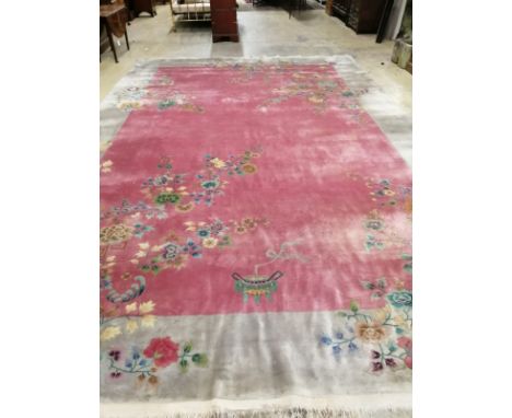 A large early 20th century Chinese cerise ground floral ground carpet, 530 x 358cm