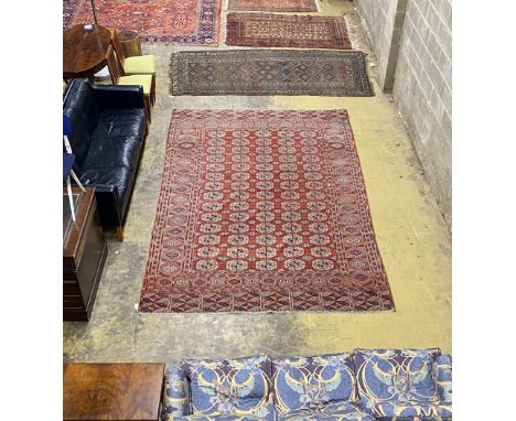 A Bokhara brick red ground carpet, 350 x 230cm