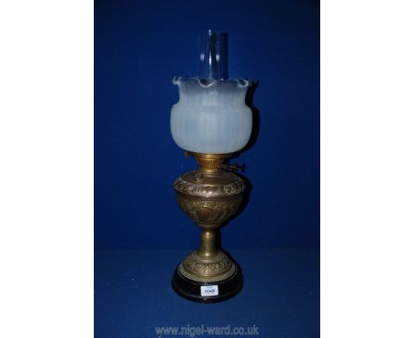 A brass oil lamp with scalloped edge shade, 23" tall.