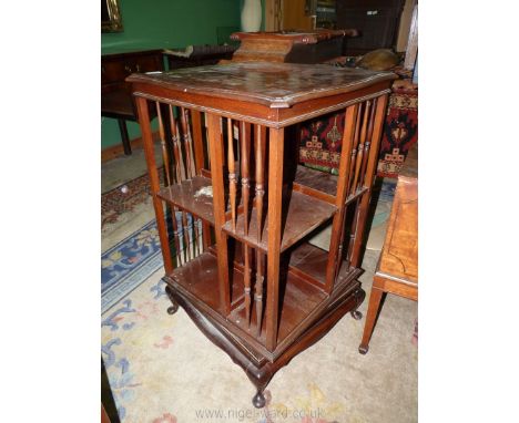 An Edwardian Mahogany revolving Bookcase having bobbin turned details, 20'' x 20'' x 33 1/2'' high standing on brief cabriole