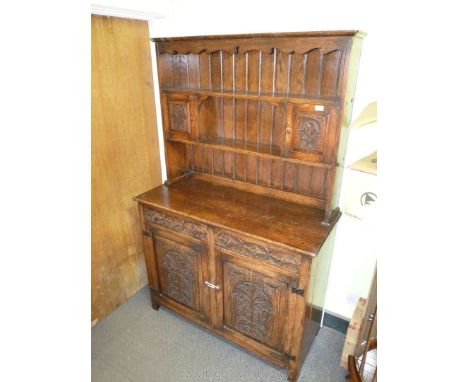 An appealing Oak dresser complete with plate rack featuring a pair of raised &amp; fielded panelled doored cupboards with car