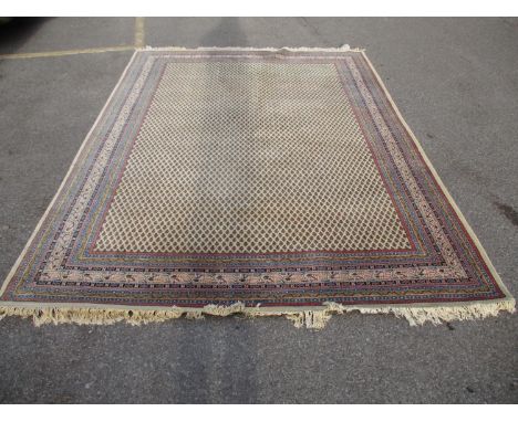 An Indian carpet with repeated boteh on a cream ground within a red, blue and yellow border, 100 x 135Location: G 