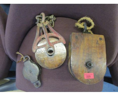 A group of three wooden and metal vintage pulleys to include an American Hudson MFG Co pulley 
