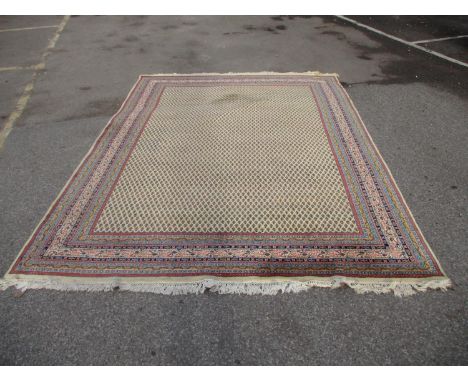 An Indian carpet with repeated boteh on a cream ground within a red, blue and yellow border 100" x 135"Location: G 